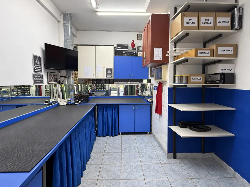 Sistem Elektronik atölyesinde mavi onarım tezgâhları ve parça rafları